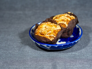 Muffins with nuts and cream filling in a blue bowl. Delicious dessert on the table. Calories and cholesterol