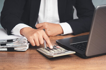 Businessman calculating finance with calculator at office desk.
