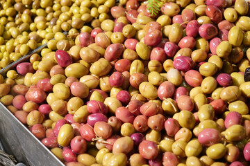 Olives in a market display during a bright sunny day