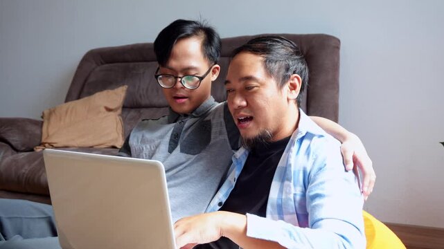 Father cheers online success with his son who has special needs sharing joy and excitement at home