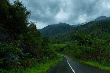 Dark and gloomy forest scenery on mountain layers landscape in Jantho, Aceh, Indonesia, with thick fog that limits visibility