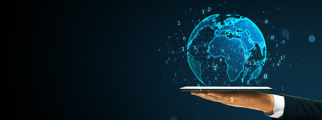 Digital world map hologram floating above tablet held by person in suit on dark background with binary code and technology concept.