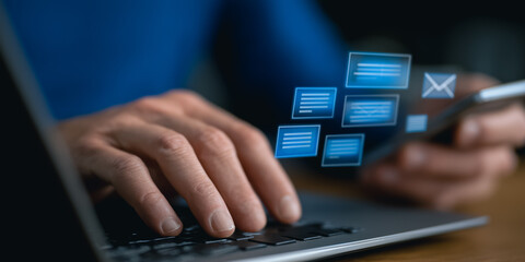 Close-up of a person engaging with modern digital technology. typing on laptop keyboard and interacting with email messages on a smart phone.