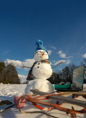 Snowman for winter greeting card. Snow man with winter background. Snowman with scarf and mittens in snow. Snowman outdoors winter fun. Snowman festive New Year outdoor.