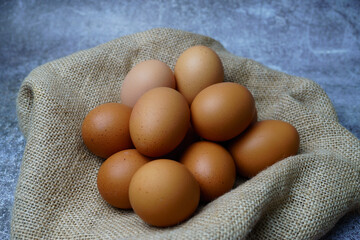 Fresh brown eggs collected in a burlap basket, highlighting organic, farm-fresh food and healthy eating concepts