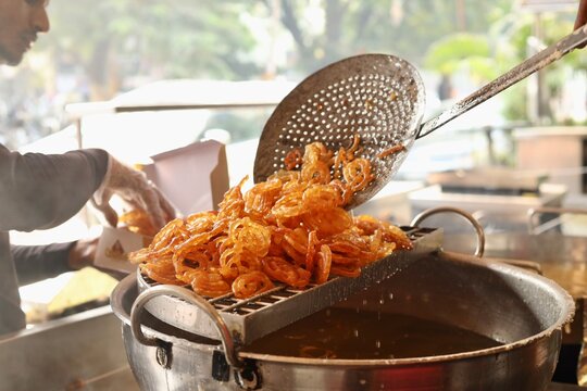 Jalebi being deep fried at a sweet shop in morning