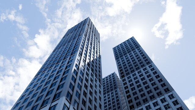 Tall buildings rise into the blue sky with scattered clouds. view looks upward, showing the modern architecture in a busy city during the day. 3d render