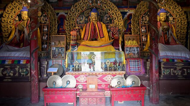 Inside Mongolia's Erdene Zuu Monastery: ancient gilded Buddhist statues, ornate altar, and traditional instruments displayed within the historic temple interior.