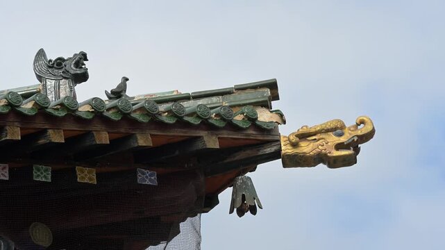 Exterior of a temple pavilion at Erdene Zuu Monastery, Mongolia. A golden Dharma Wheel and deer adorn the green tiled roof, highlighting the 16th-century Buddhist artistry of this historic site.