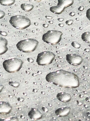 Sparkling water droplets on a reflective metallic surface