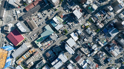 Drone directly above aerial view of modern city buildings and roads.
