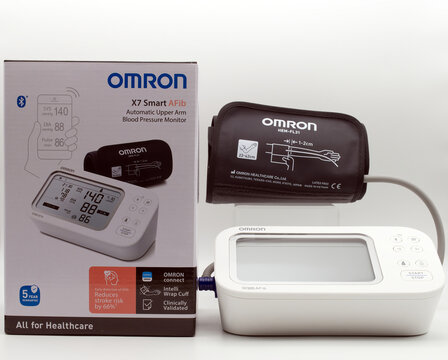Bologna - Iytaly - December 9, 2025: Omron x7 smart afib automatic upper arm blood pressure monitor with cuff and retail packaging isolated on white background.