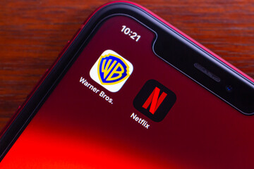 Obraz premium Quito, ECUADOR - Dec 9 2025 : Netflix and Warner Bros icons are seen on an iPhone, symbolizing the high-profile acquisition talks, industry consolidation and the change of global streaming service.