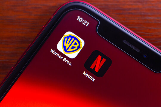 Quito, ECUADOR - Dec 9 2025 : Netflix and Warner Bros icons are seen on an iPhone, symbolizing the high-profile acquisition talks, industry consolidation and the change of global streaming service.