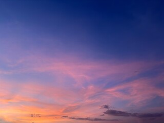 Obraz premium Beautiful twilight sky with pink and purple clouds during sunset, soft gradient colors creating a dreamy and peaceful sky background.
