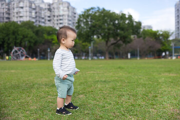Baby playing at the park on grass