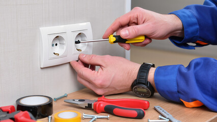 electrician repairing electrical outlet