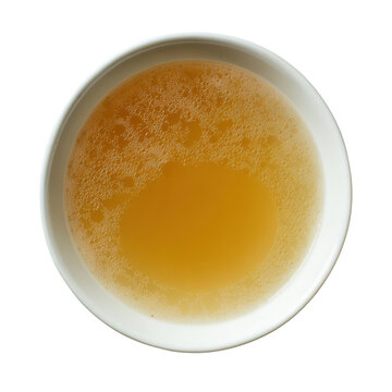 Overhead view of a white bowl filled with golden chicken broth and small bubbles food liquid, Png On White Background, Isolated on Transparent Background, Cut Out
