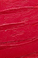 Rich red lipstick texture with smooth application and glossy finish, background for beauty and cosmetic themes. Red lipstick background