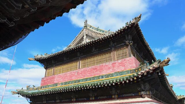 Scenic exterior of the historic temples at Erdene Zuu. The 16th-century structures display ornate green eaves against the sky, preserving the ancient religious artistry of Karakorum.