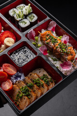 Vegetable bento box with vegan dishes on a dark background isolated