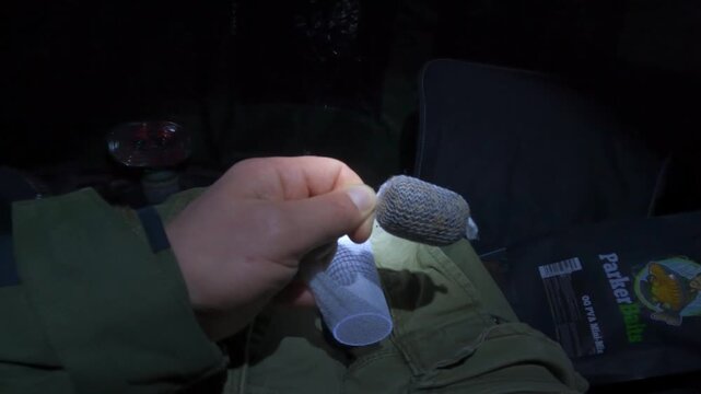 Carp fishing with PVA bags at night, capturing angler&rsquo;s focused moment