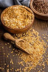 Golden linseed or flaxseed. Healthy flax seed on scoop on wooden table.