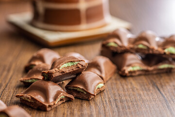 Chocolate bar with pistachios cream on wooden table.
