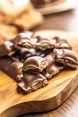 Chocolate bar with pistachios cream on wooden table.
