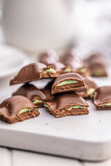 Chocolate bar with pistachios cream on white table.