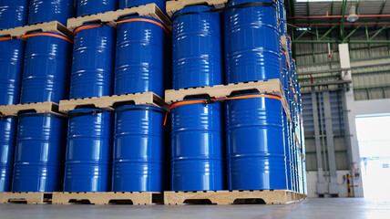 Warehouse stocked with numerous blue steel drums, barrels tank, which are containers used for shipping bulk cargo. chemical storage, warehouse management