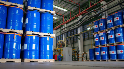 Warehouse stocked with numerous blue steel drums, barrels tank, which are containers used for shipping bulk cargo. chemical storage, warehouse management