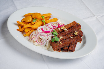 Delightful plate of golden fried potatoes and flavorful, crispy strips topped with onions