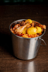 A vibrant seafood boil features juicy chicken, corn, and potatoes in a rustic metal bucket