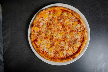 Bright, juicy pineapple adorns the cheesy pizza, inviting a delicious feast in a cozy setting