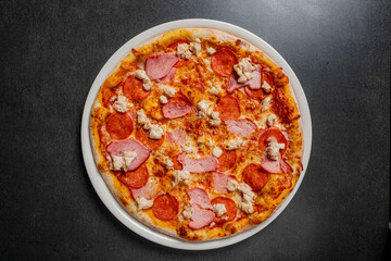 A delicious pizza with pepperoni, ham, and cheese awaits on a rustic table, inviting all