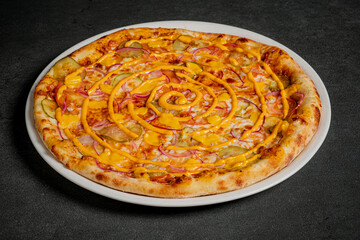 A freshly baked pizza with melted cheese awaits its eager taster on a dark surface