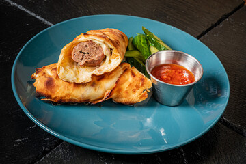 Delicious pastry roll filled with meat and paired with tangy dipping sauce and green vegetables