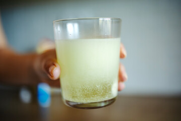 Hand holding glass with effervescent medicine dissolving