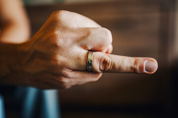 Hand showing middle finger rude gesture with ring