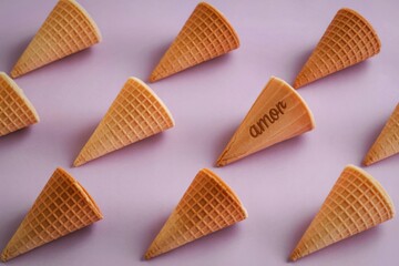 Many empty ice cream cones arranged in rows on a light purple background