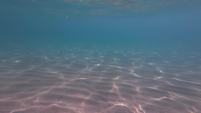 Sunlit Underwater Seafloor Green Water Rippling, Sandy Bottom With Scattered Sediment And Soft Light Shafts,