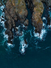 Waves crashing against rugged coastline at sunset, showcasing nature's beauty and strength