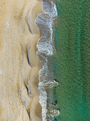 Waves gently caress the sandy shore at sunset, creating a serene beach atmosphere perfect for reflection and relaxation