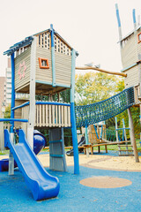 Colorful playground structure invites children to explore and play amidst a serene urban park setting during late afternoon
