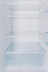 Clean, Empty Refrigerator Interior with Glass Shelves and Storage Drawer for Optimal Food Organization and Freshness Maintenance