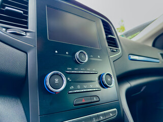 Dashboard of a modern vehicle showing controls and display during a sunny day drive in a serene environment