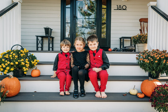 Children posing for family portrait on autumn porch