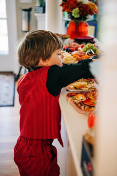 Young boy reaching for food at autumn holiday celebration