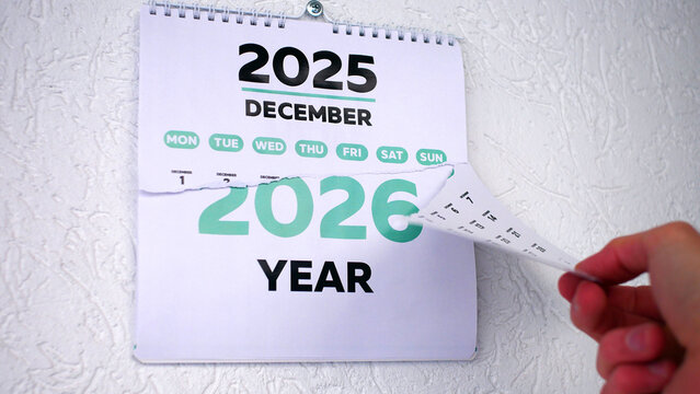A male hand tearing off a wall calendar December page 2025 followed by the next one with the number of a New Year 2026